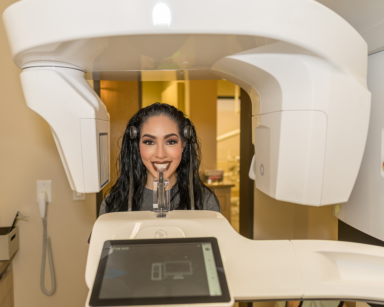 Beautiful young Hispanic woman taking x-ray while smiling with white teeth